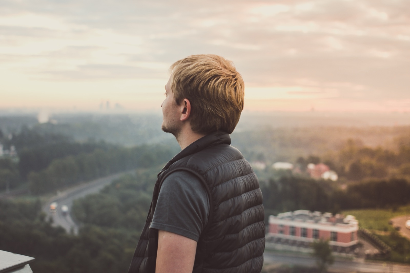 A person looking out over a landscape at dawn
